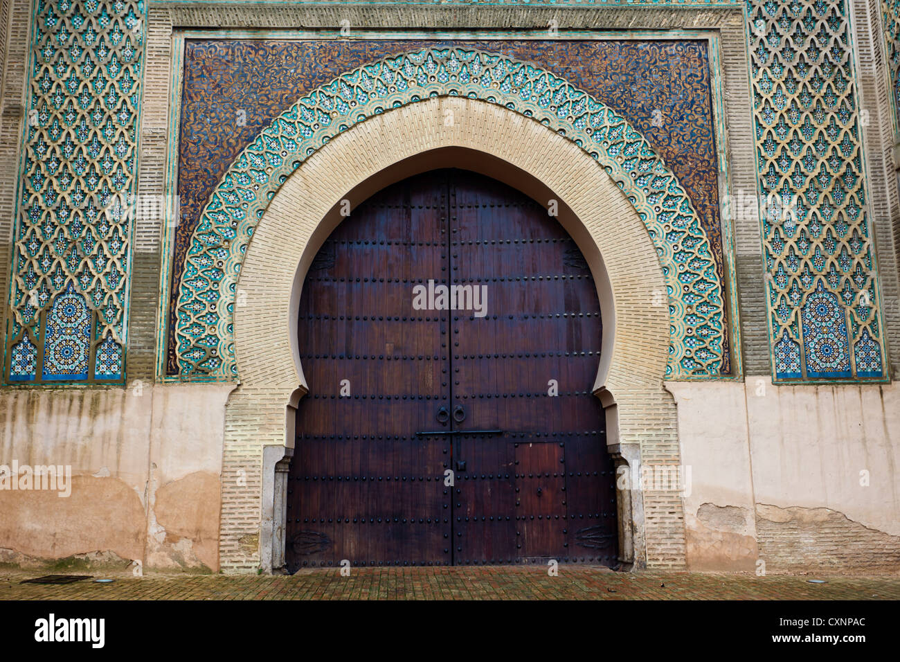 Closeup of mosaic tile designs and wooden arched exterior door to Mosque in Meknes, Morocco. Stock Photo