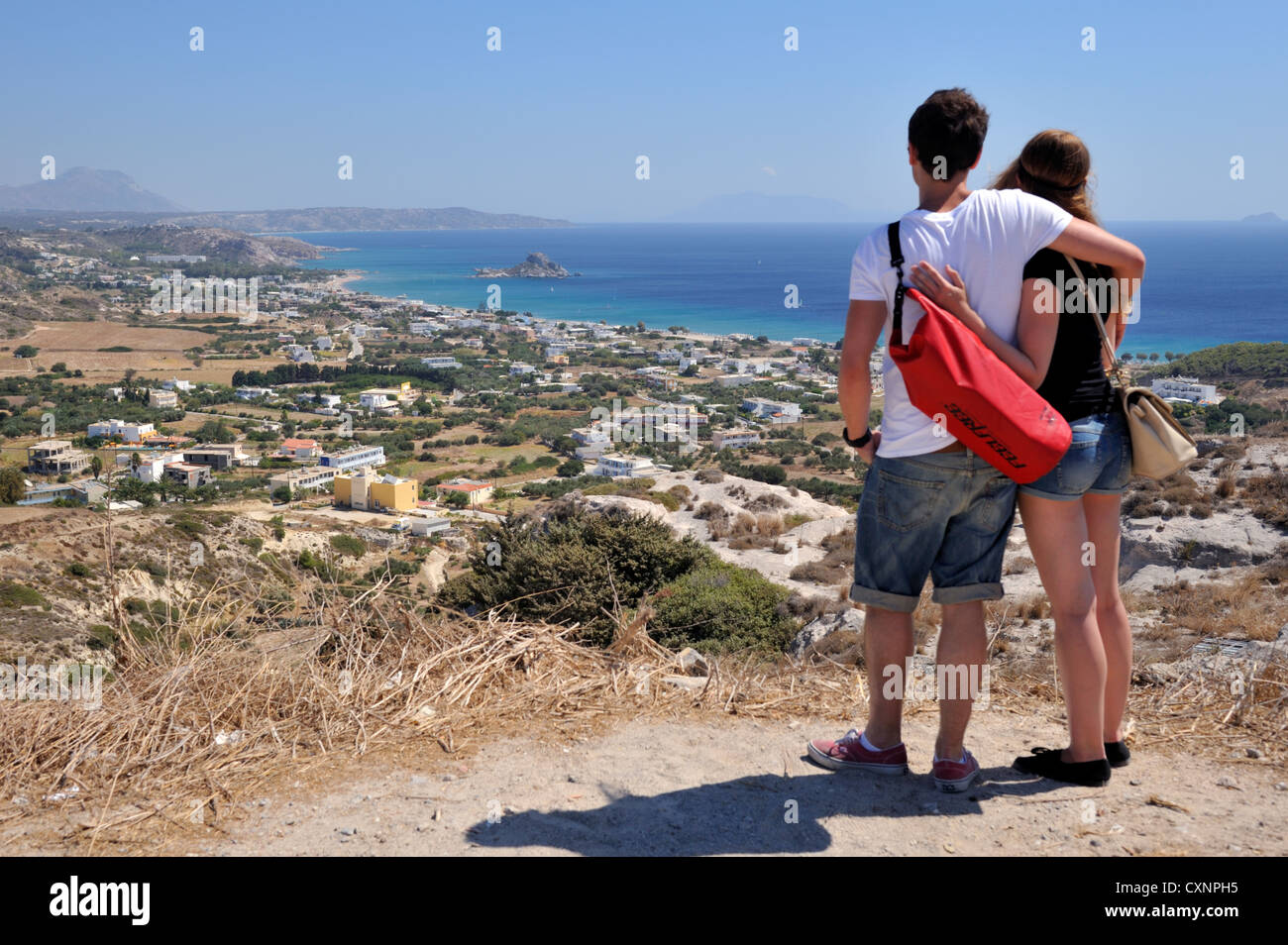 Couple overlooking town of Kefalos on Aegean sea on island of Kos, Greece Stock Photo