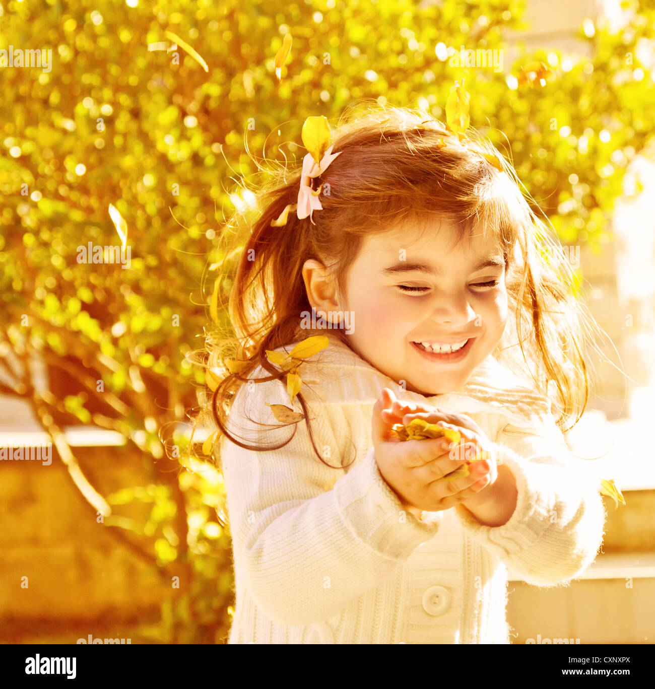 Photo of pretty happy little girl enjoying autumn nature in park