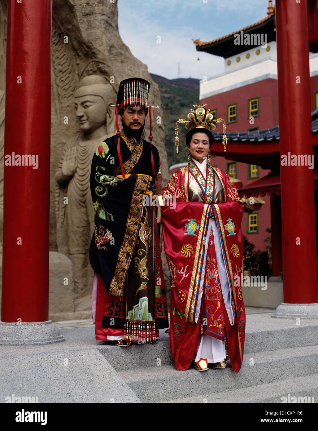 Hong Kong. Middle Kingdom. Two Chinese people in traditional Sing Dynasty clothes. Man and woman posing on temple garden steps. Stock Photo