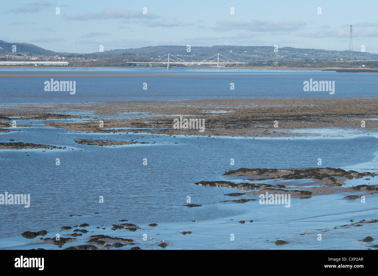 Severn estuary at low tide beside the new Severn bridge looking up channel toward the old bridge in the distance Stock Photo