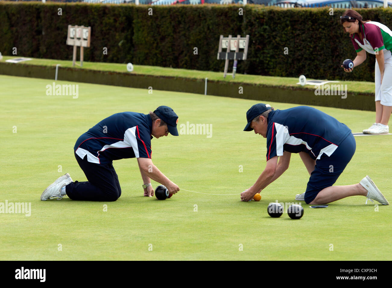 Bowls umpires measuring distance of bowl from jack Stock Photo