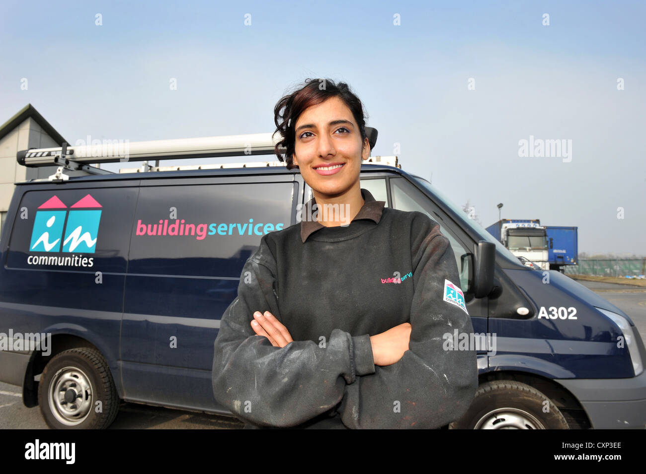 Portrait of a young plumbing apprentice in front of her work van. Stock Photo