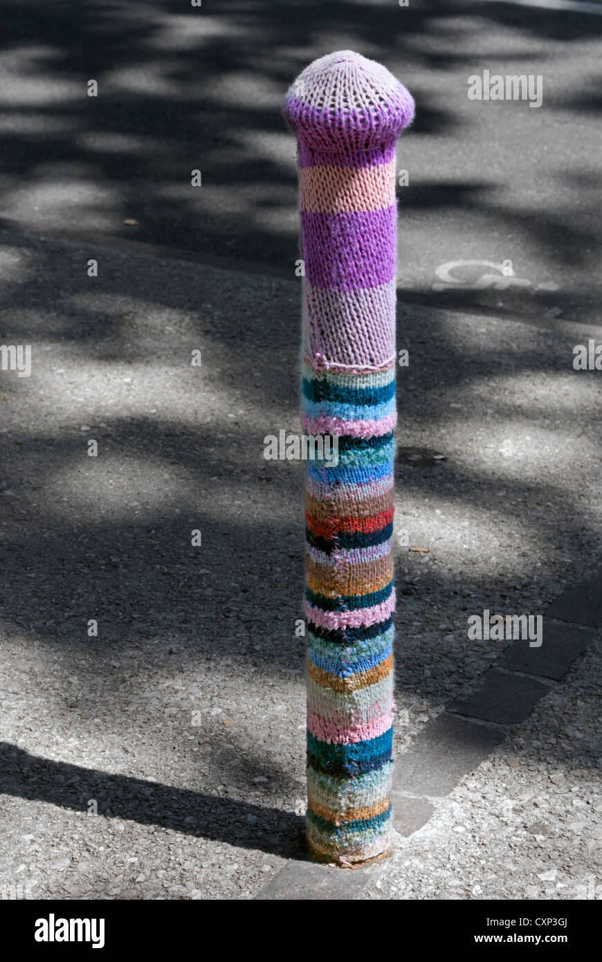 Yarn bombing in Cahors, France.  A bollard gets a colourful covering Stock Photo
