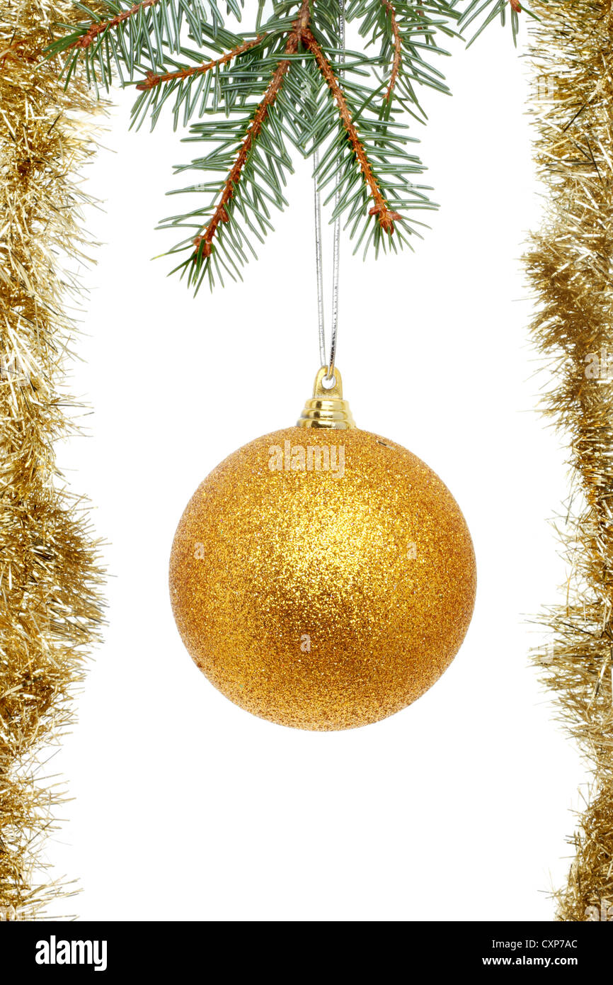 Gold glitter Christmas bauble and tinsel hanging from a Christmas tree branch Stock Photo