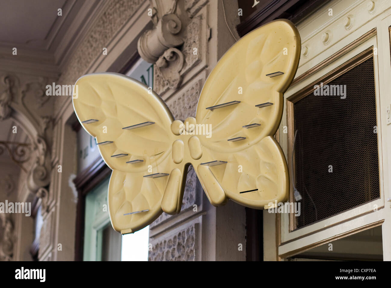 Golden Butterfly Sculpture on the side of a shop front Stock Photo
