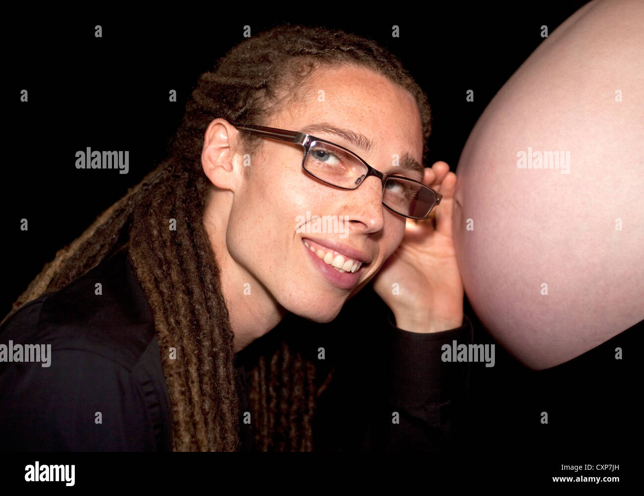 Expectant father listing for sounds of his unborn son at his wife's stomach Stock Photo