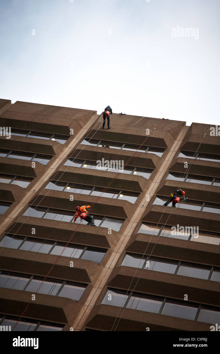 3 window cleaners on highrise building in Manchester UK Stock Photo