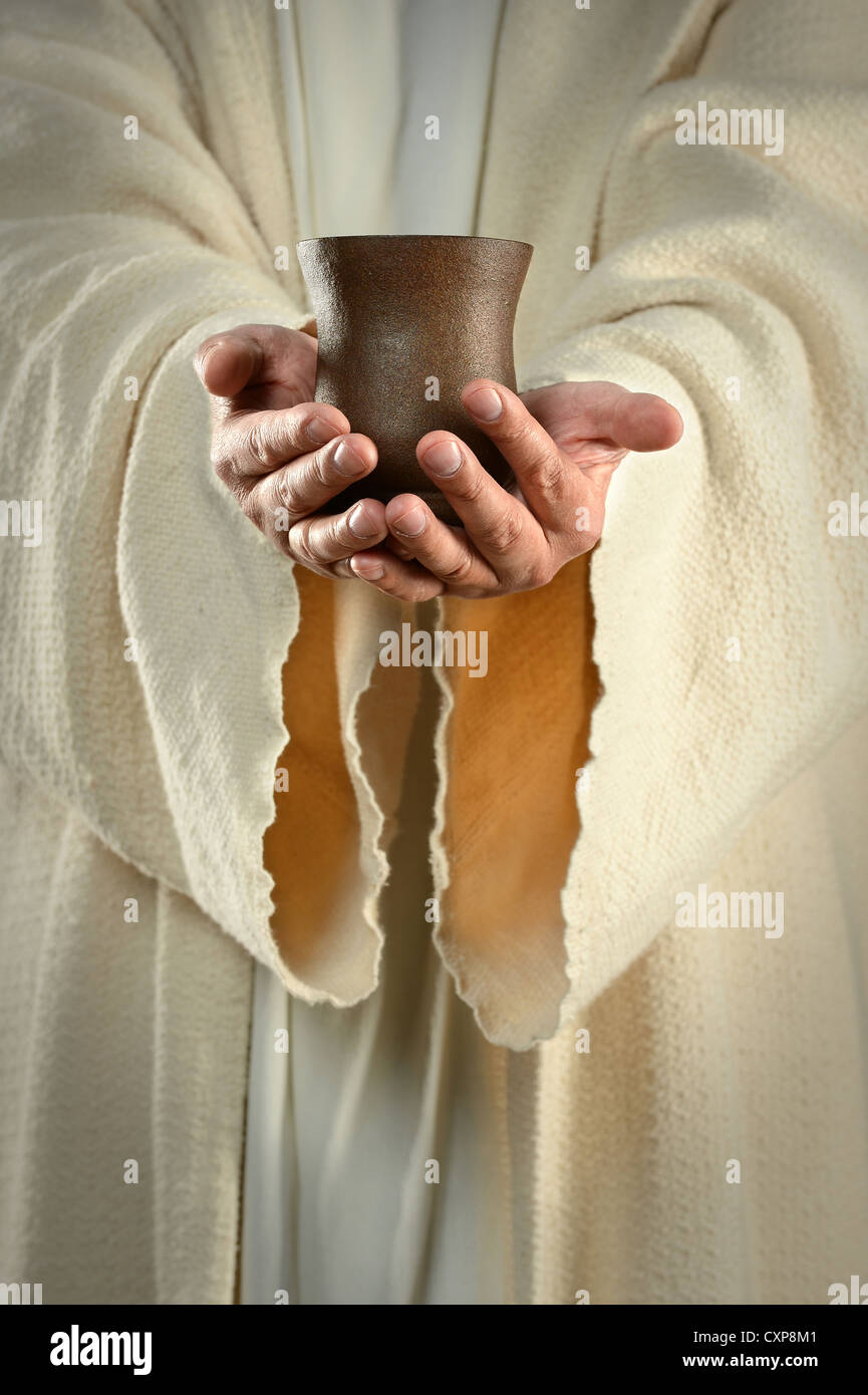 Hands of Jesus holding cup of wine Stock Photo