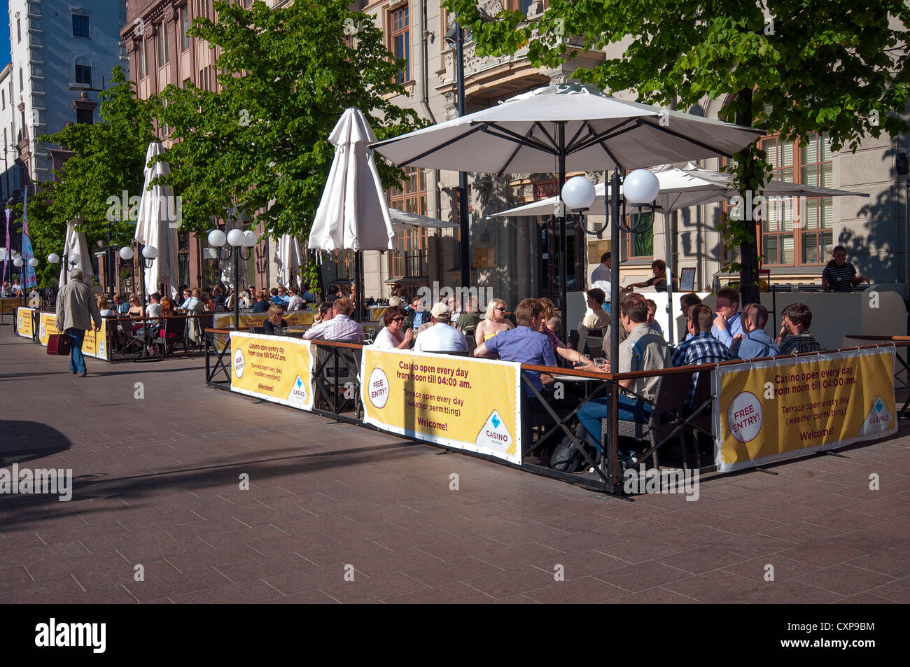 People sitting outside bars around Railway Square enjoying the Finnish summer sun, Helsinki, Finland Stock Photo