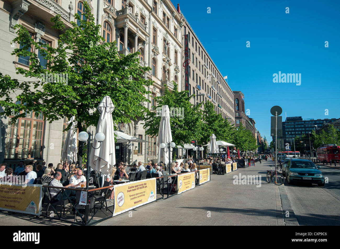 People sitting outside bars around Railway Square enjoying the Finnish summer sun, Helsinki, Finland Stock Photo