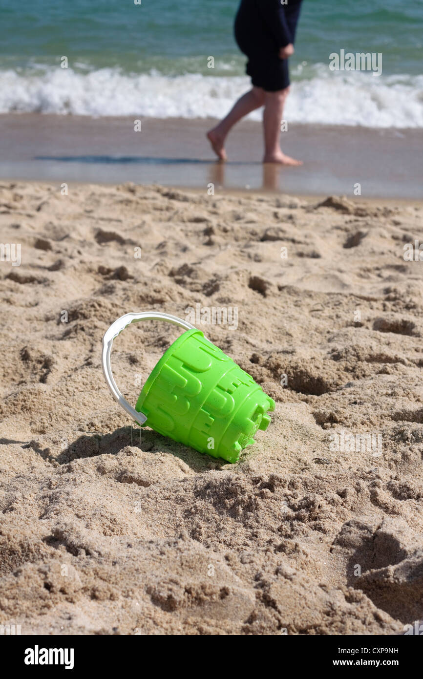 Empty green bucket on beach Stock Photo