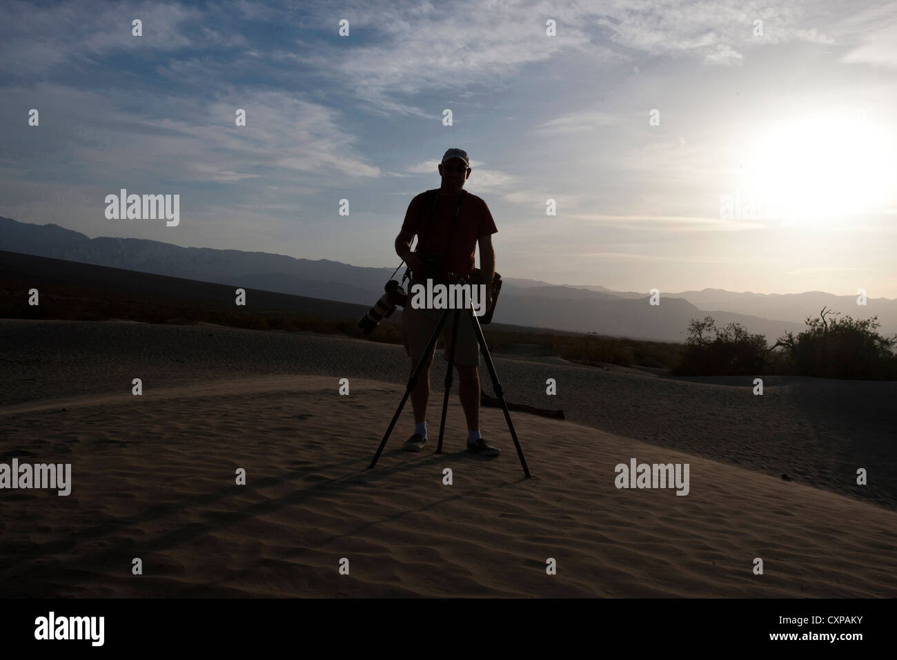 Silhouette adult male photographer with tripod and camera Sand dunes Mesquite Dunes Death Valley National Park California Stock Photo
