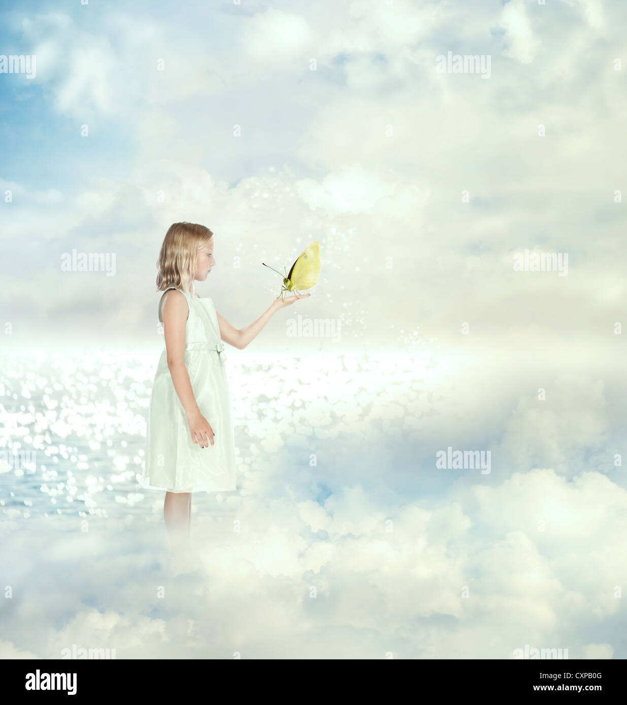Little girl holding a butterfly on the clouds Stock Photo