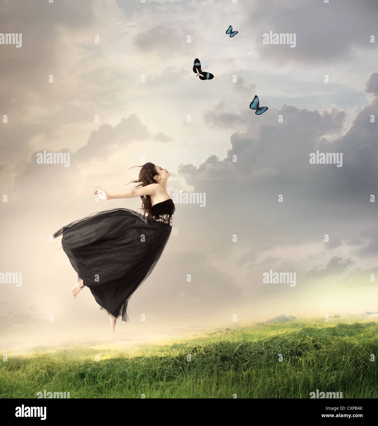 Beautiful Girl Jumping in the Air on a Mountain Stock Photo