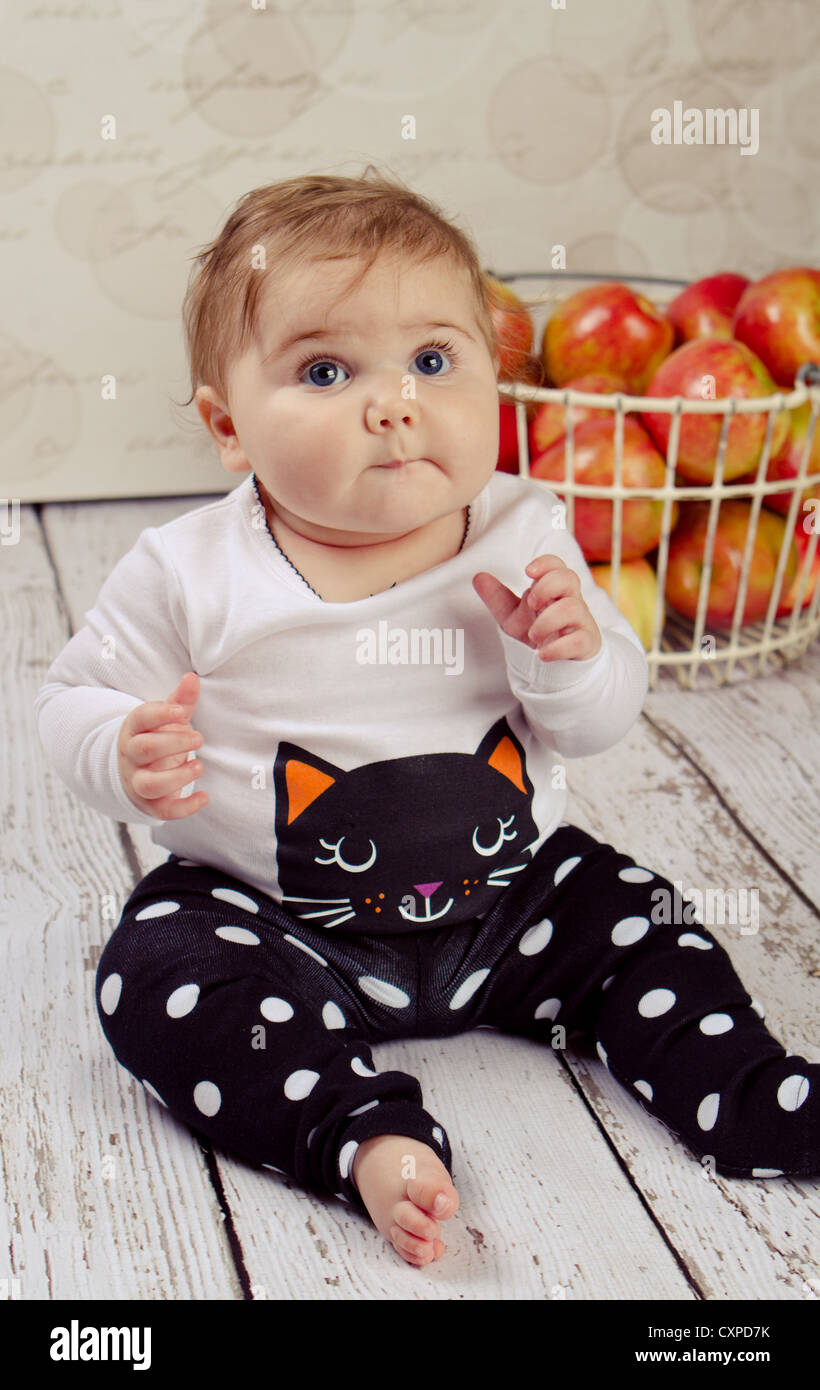 6 month old baby girl in her Halloween outfit sitting next to a