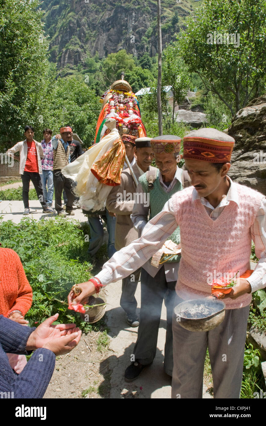 A Hindu ritual procession halts to give flowers in return for offerings of money Stock Photo