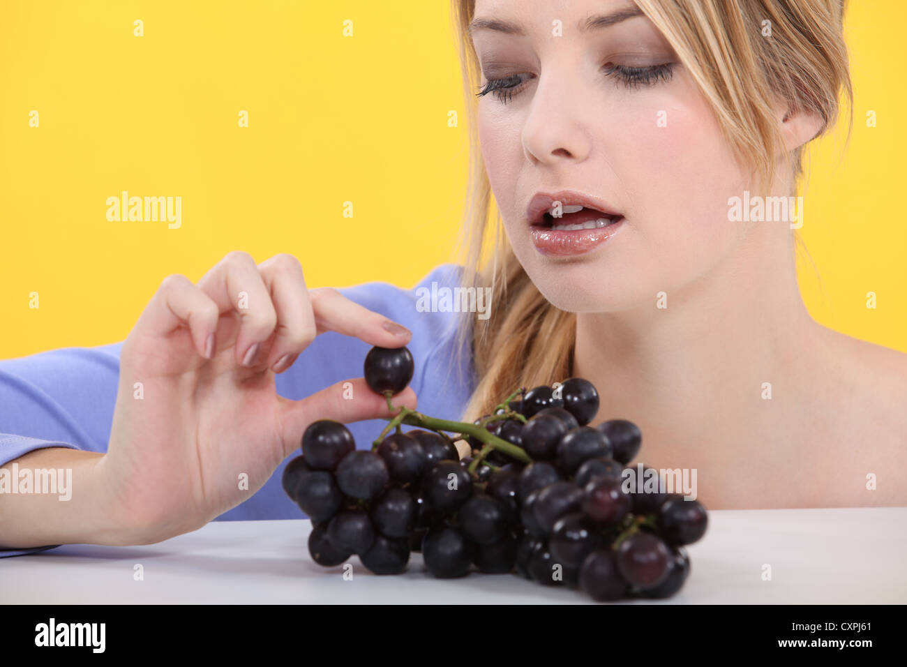Woman eating grapes Stock Photo - Alamy