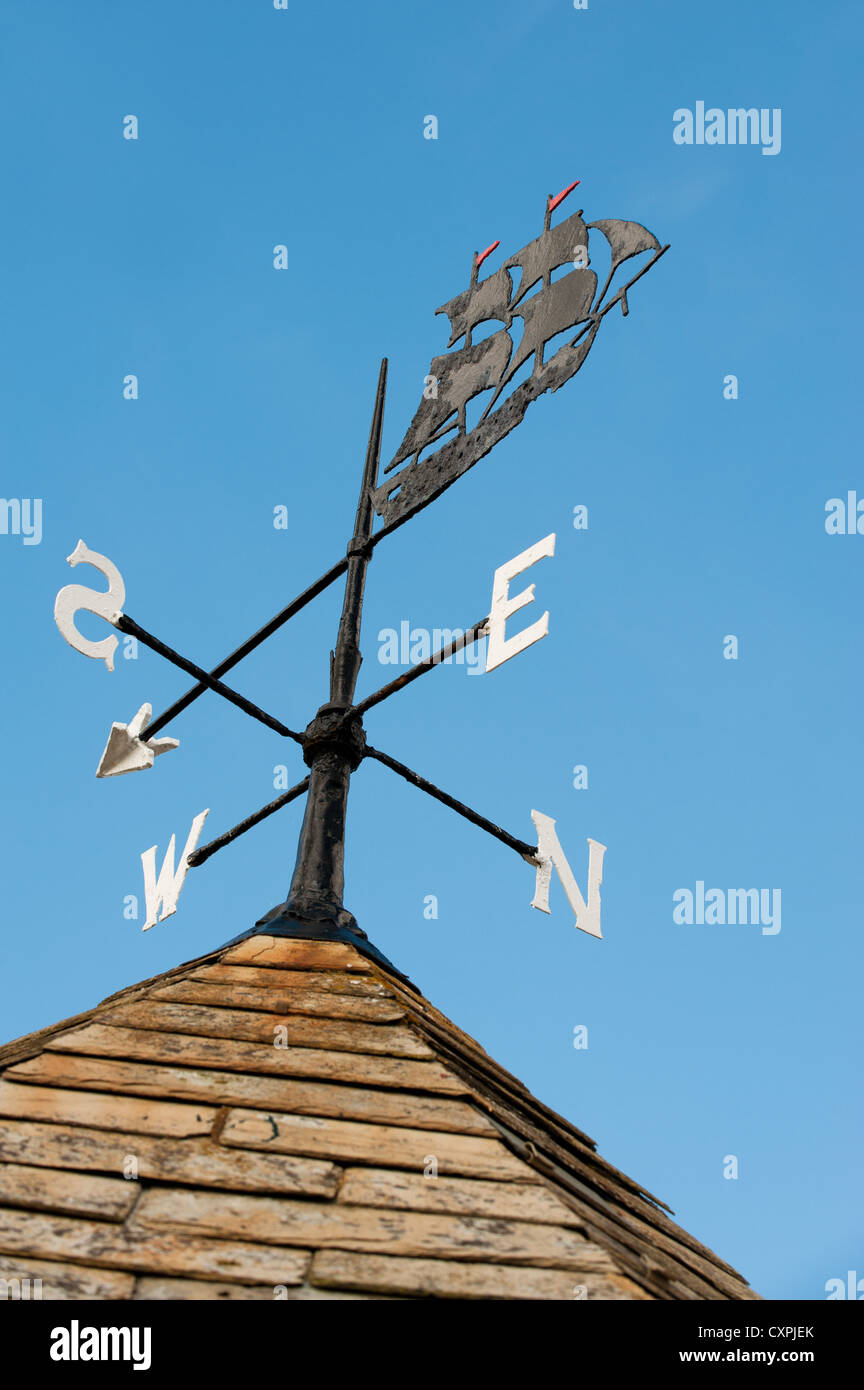 A wind vane on a roof. Stock Photo