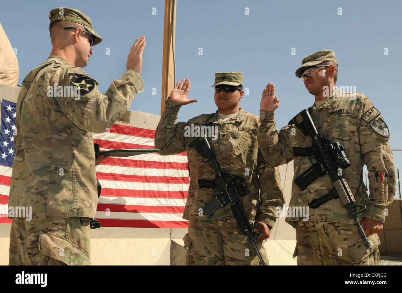 From right, Staff Sgt. Josuel Cruz, of Orlando, Fla., and Spc. Joseph Tauiliili, from the village of Vailoa, American Samoa, reenlist in the Army during a ceremony at Forward Operating Base Spin Boldak, Afghanistan, Oct. 7, 2012. The soldiers are with the 2nd Infantry Division's 5th Battalion, 20th Infantry Regiment. The 5-20th Infantry is part of the 3rd Stryker Brigade Combat Team from Joint Base Lewis-McChord, Wash. Stock Photo