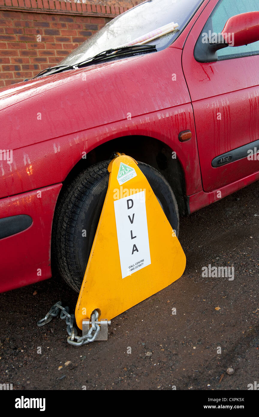 DVLA wheel clamp on a untaxed car parked on a street in England Stock Photo Alamy