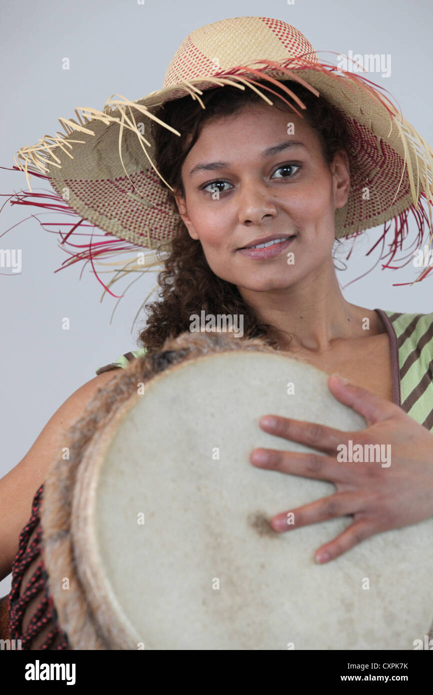 Woman wearing a straw hat and playing the djembe Stock Photo Alamy