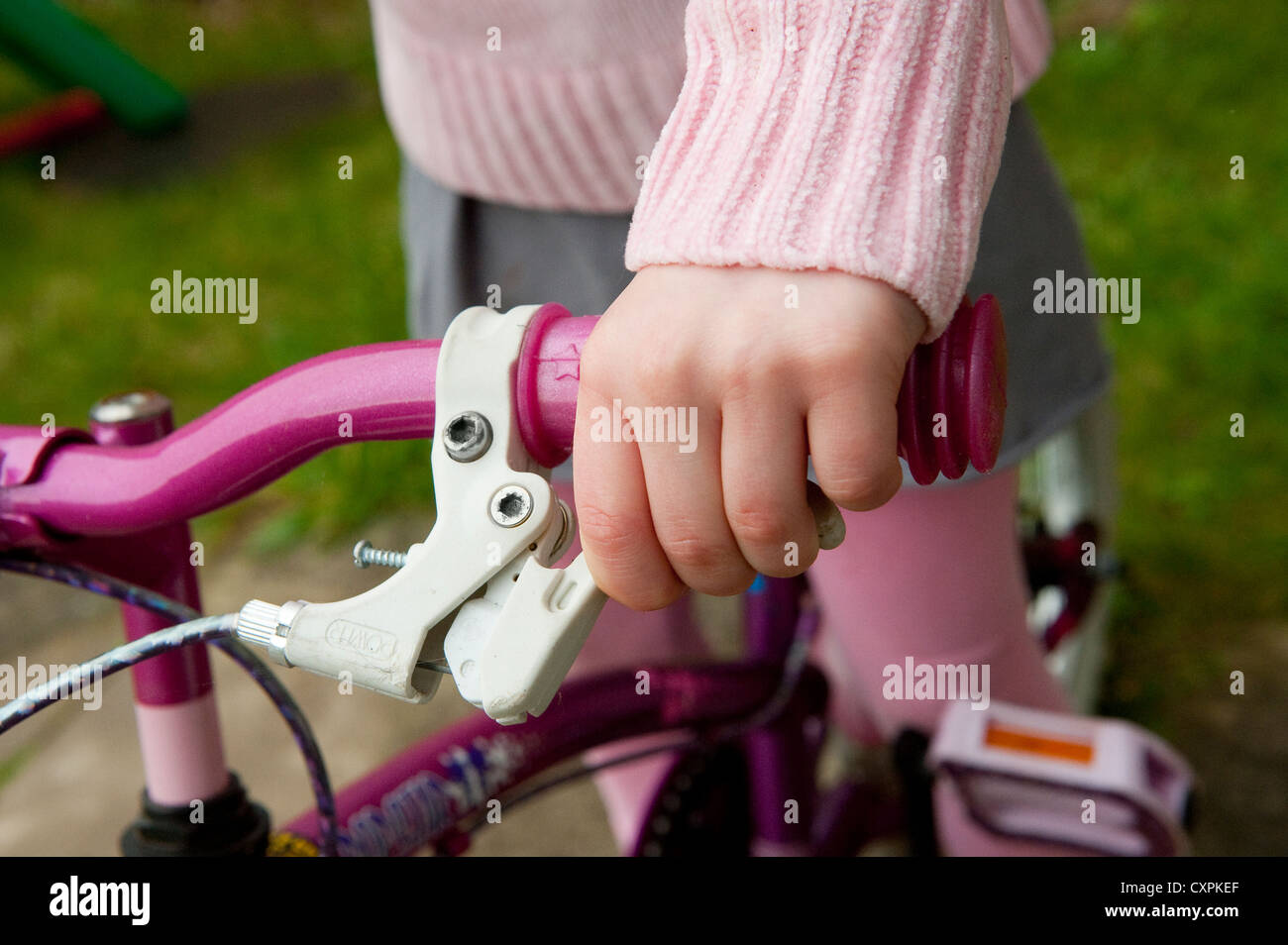 Close up of a child's hand applying the brakes on a bicycle Stock Photo