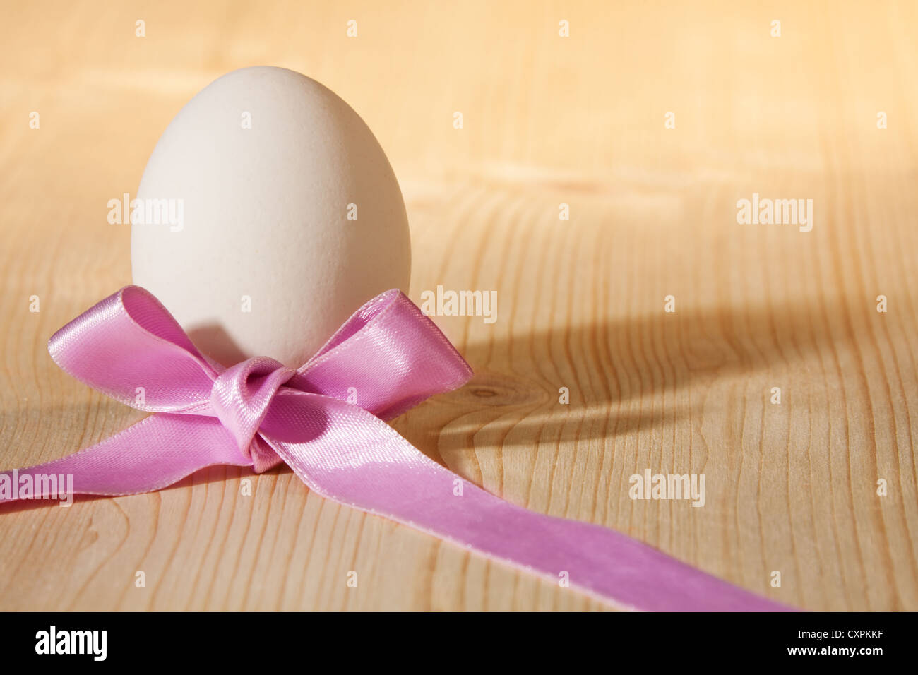 white egg with pink ribbon bow Stock Photo - Alamy