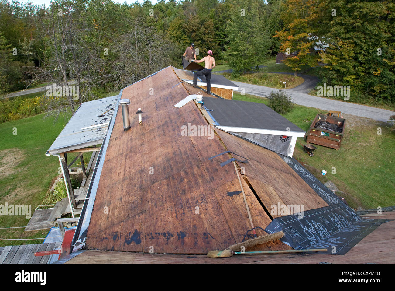 Man working on house roof, home repair Stock Photo