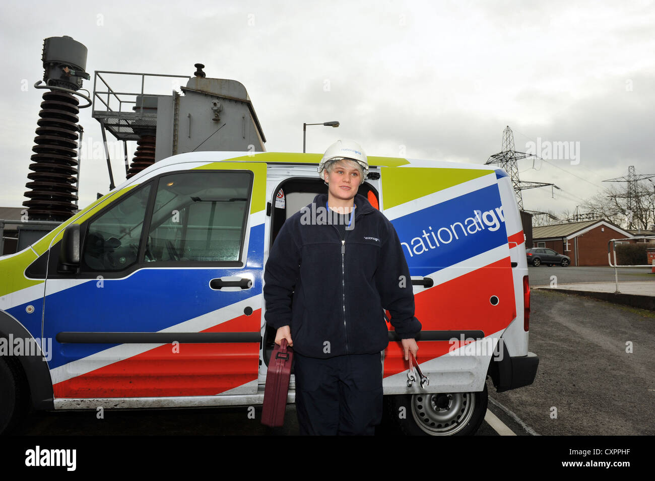 Apprentice working for a Power Company training to be a technician with her van Stock Photo