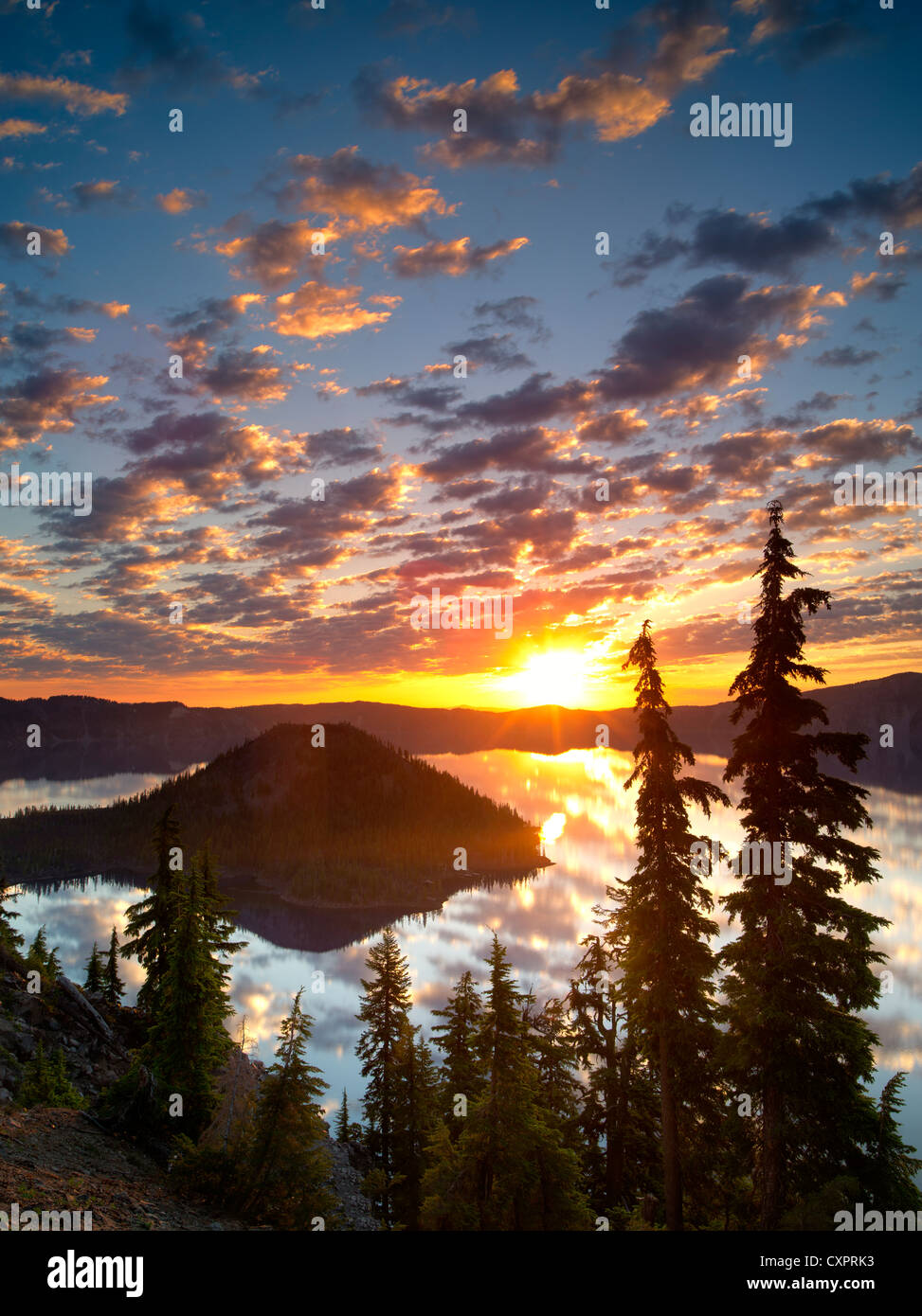 Sunrise on Crater Lake with Wizard Island. Crater Lake National Park. Oregon reflection,sun,silhouette,forest, Stock Photo