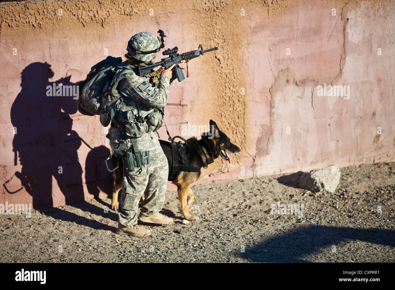 A US Army Sergeant with her Military Working Dog Jalk on patrol September 20, 2012 at the US Army Yuma Proving Grounds during the Inter-service Advanced Skills K-9 Course. The three-week course which trains Military Working Dog teams for deployments to austere environments such as Afghanistan, preparing them for the life-saving role they will perform searching for improvised explosive devices and bomb making materials. Stock Photo