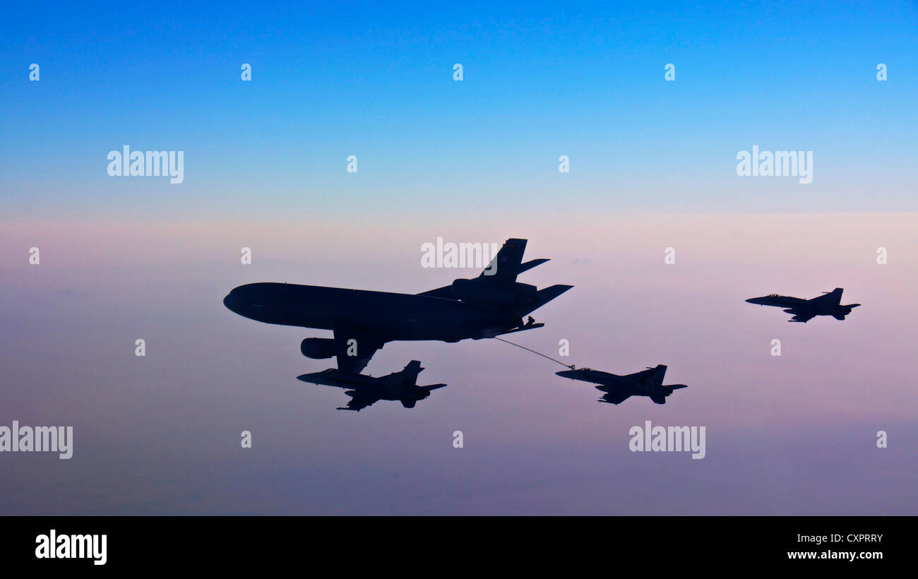 US Navy F/A-18 Hornets and Super Hornets from conduct aerial refueling during sunrise with a KC-10A Extender October 2, 2012 over the Arabian Sea. Stock Photo