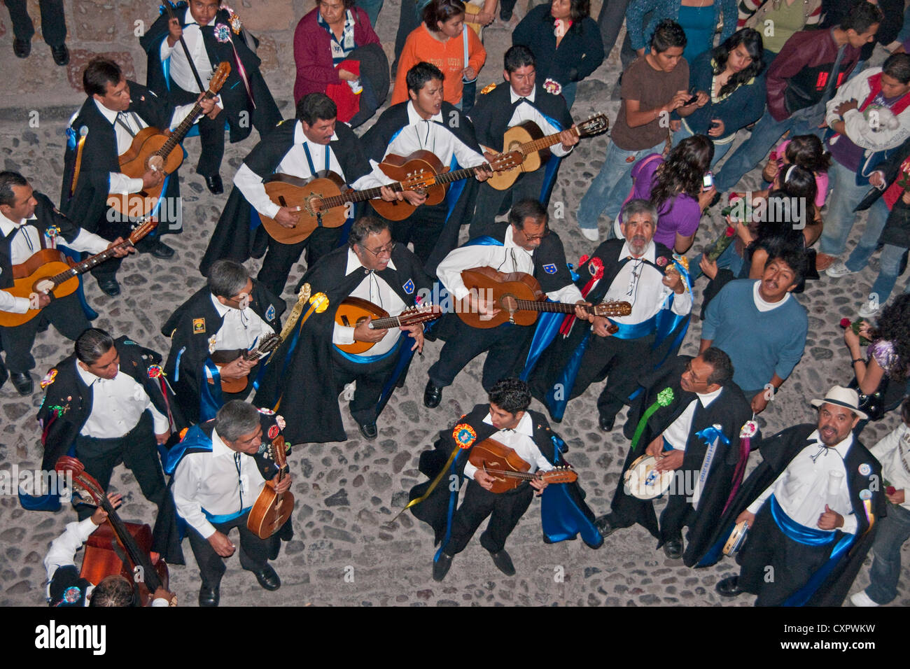 San Miguel de Allende revelers in evening on Cuna de Allende street of cobble stones near El Jardin central square Stock Photo