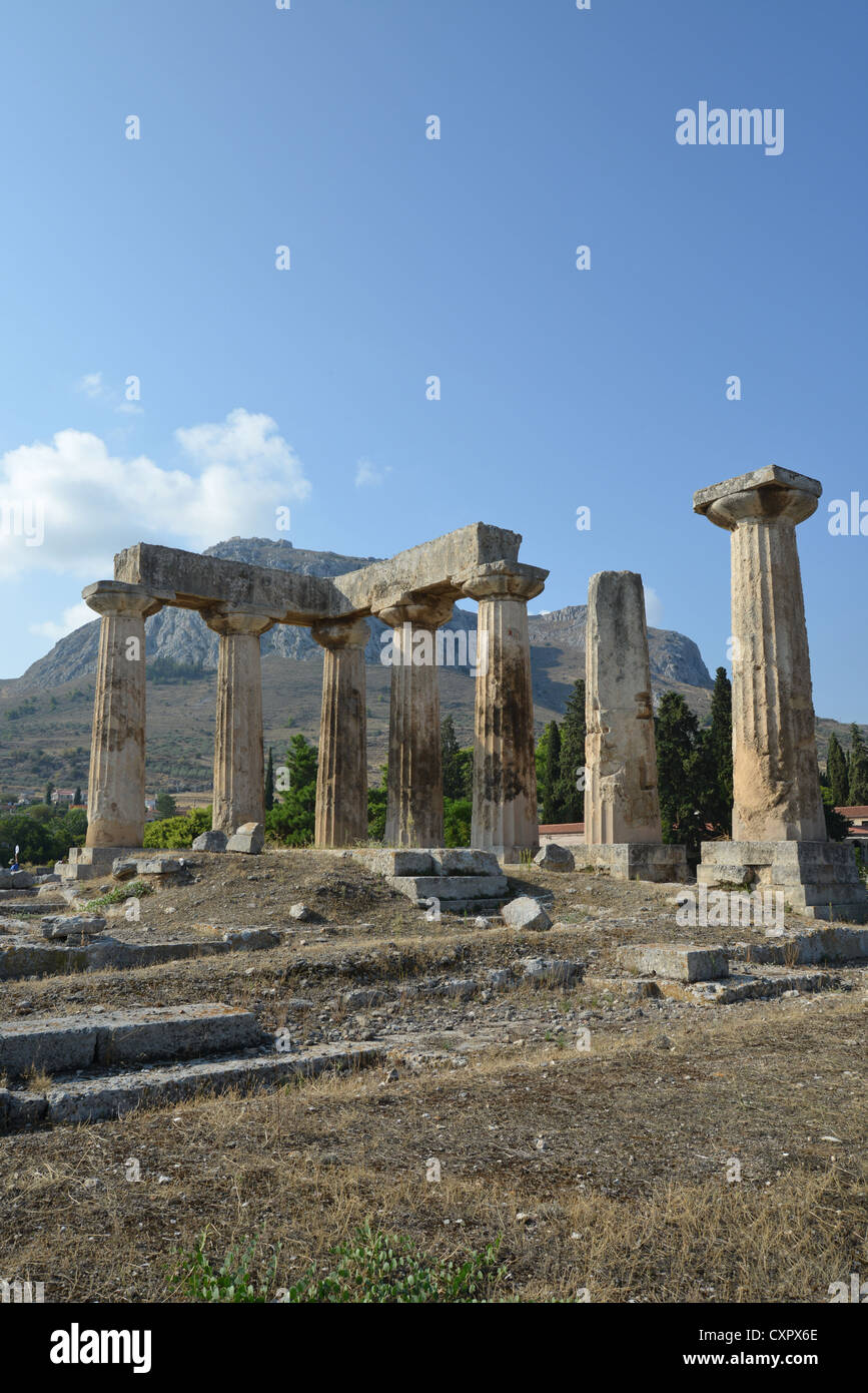 6th century BC Temple of Apollo with Acrocorinth Rock behind, Ancient Corinth, Corinth Municipality, Peloponnese region, Greece Stock Photo