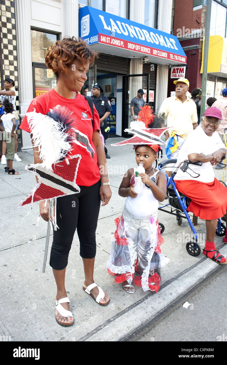 U.S.A.: Brooklyn, NY. Girl representing Trinidad and Tobago and her mom take a break during the Caribbean Kiddies Day Parade. Stock Photo