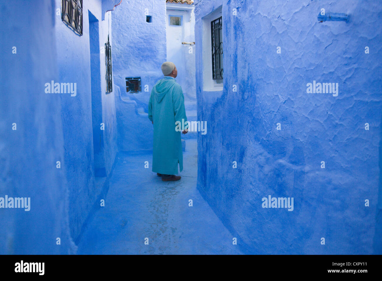 Man in traditional blue house, Chefchaouen, Morocco Stock Photo