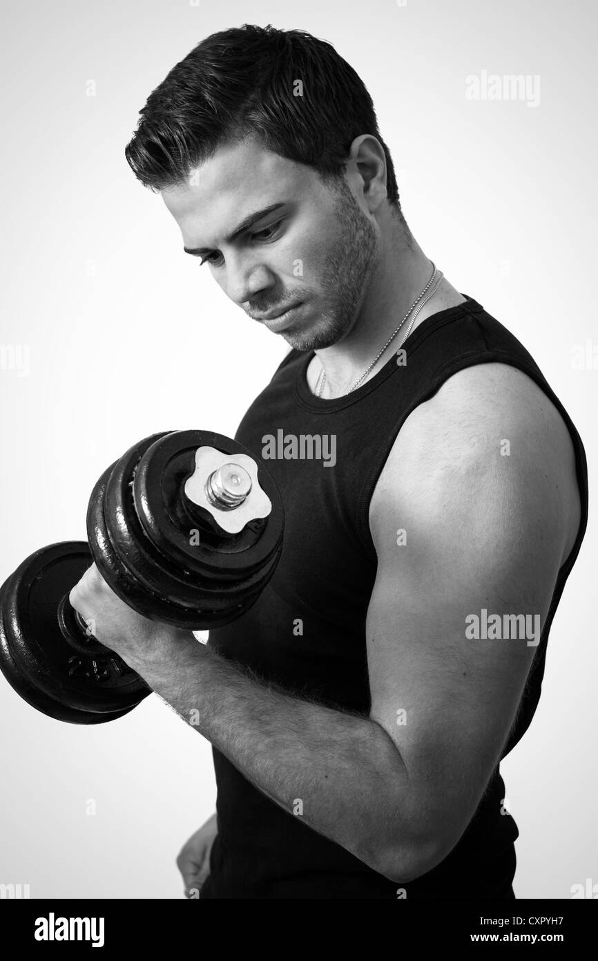 Young attractive man pumping weights in a black tank top Stock Photo