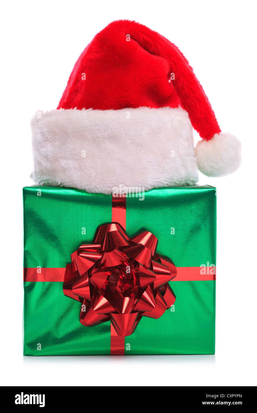 Photo of a Santa Claus hat on a green gift wrapped present with large red bow and ribbon, isolated on a white background. Stock Photo