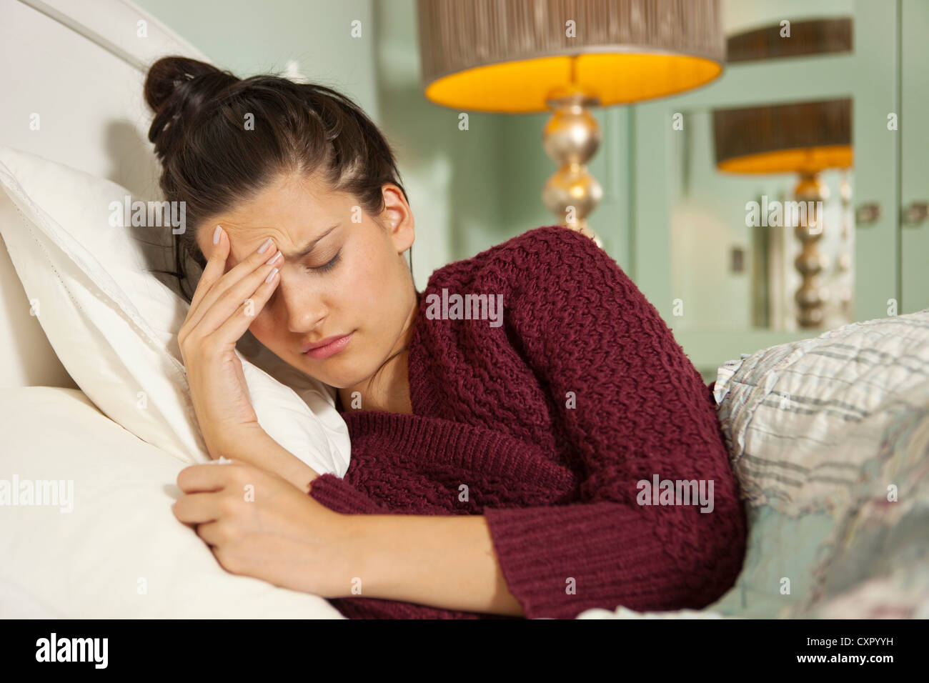 Young woman in bed with headache Stock Photo Alamy