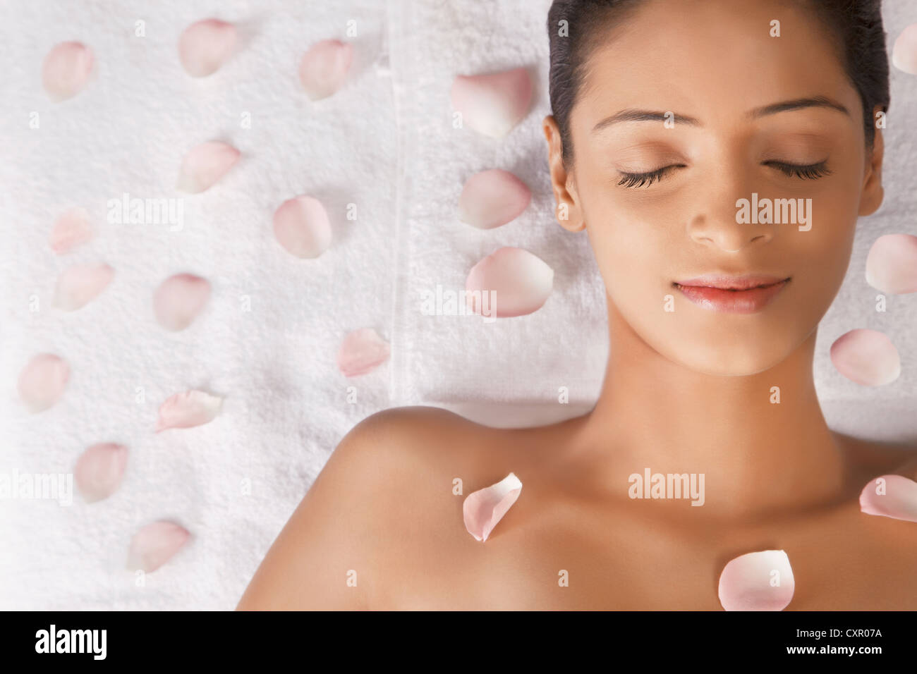 Woman lying on massage table with petals Stock Photo