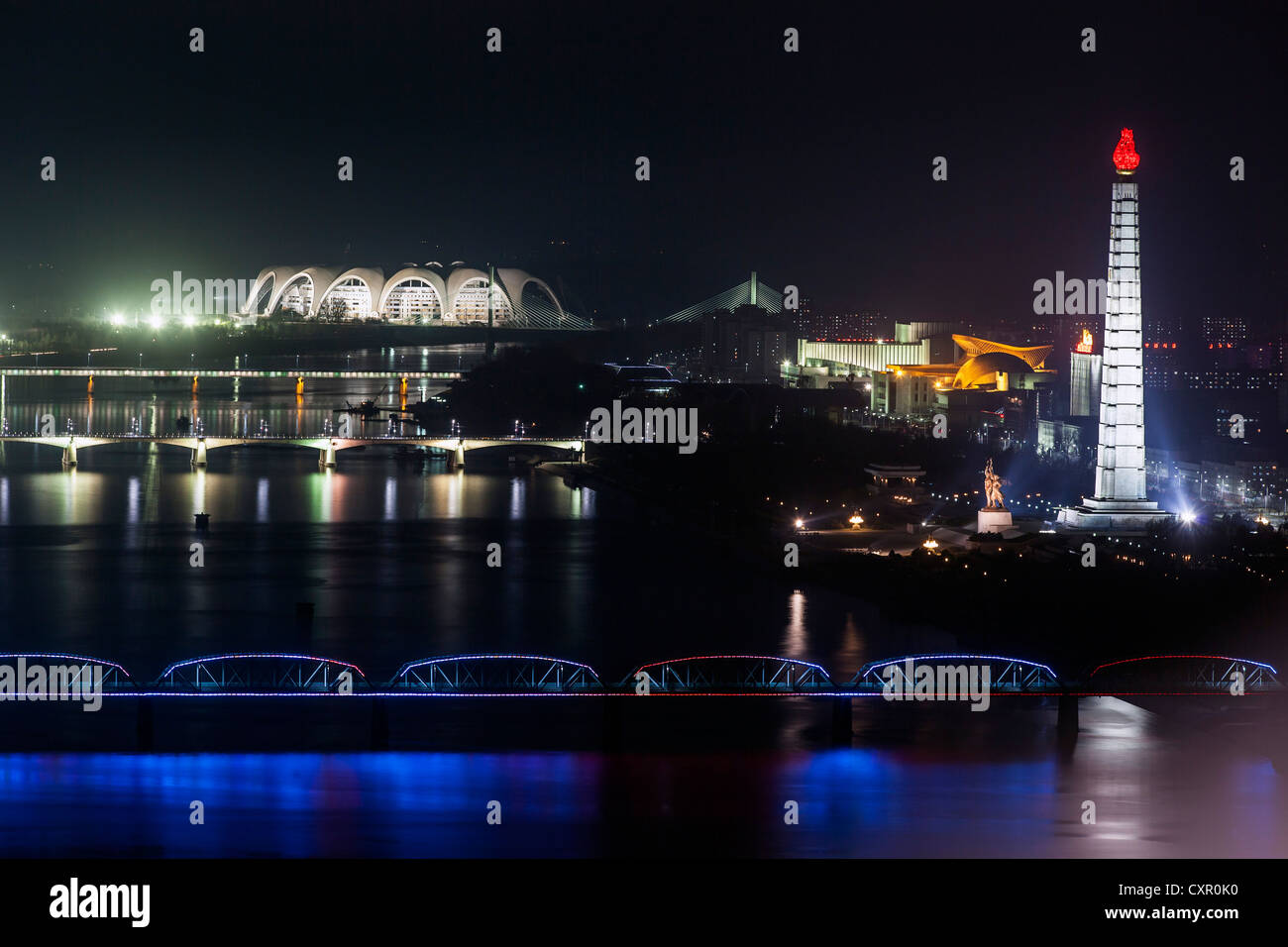 Democratic Peoples's Republic of Korea (DPRK), North Korea, Pyongyang, Juche Tower and Taedong river illuminated at night Stock Photo