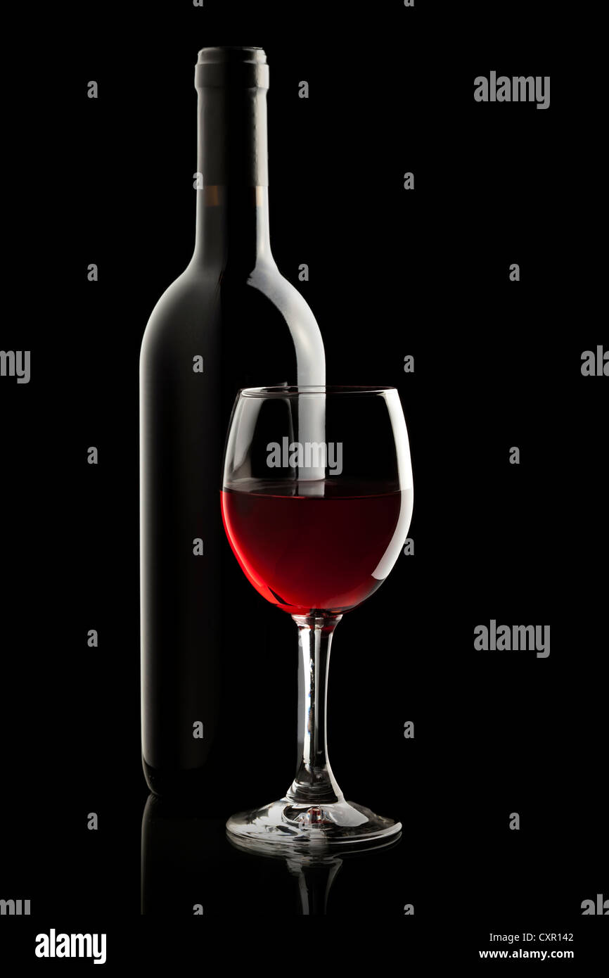 Elegant red wine glass and a wine bottle in black background Stock