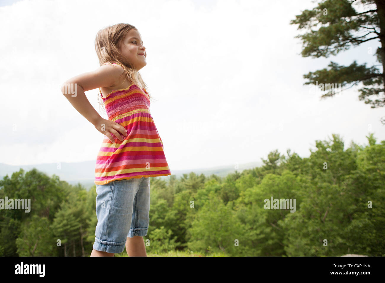 Girl with hands on hips near forest Stock Photo