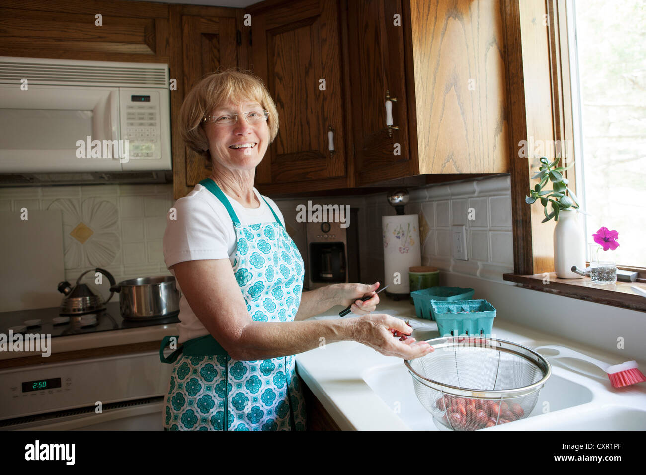 Woman preparing strawberries in kitchen Stock Photo