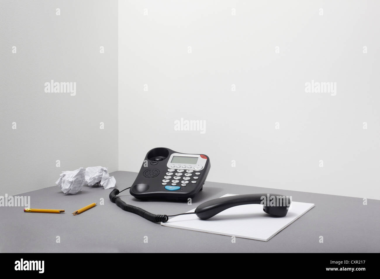 Landline office phone off the hook with pencil and paper Stock Photo