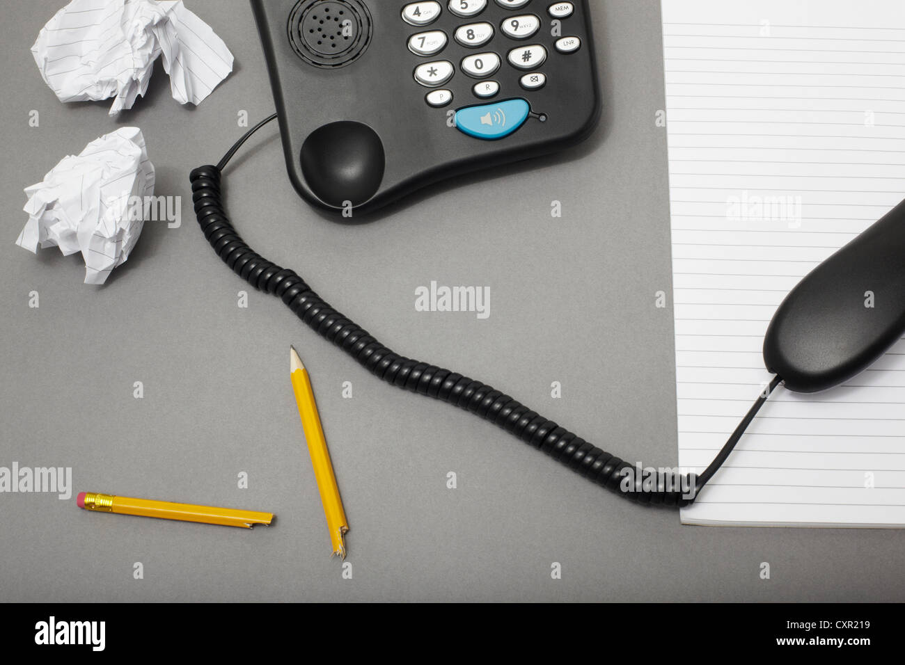 Landline office phone off the hook with pencil and paper, high angle Stock Photo