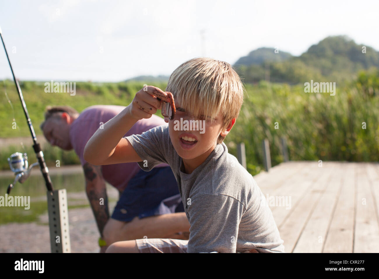 Father and son fishing, boy holding worm Stock Photo
