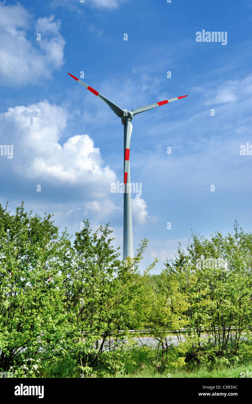 White wind turbine electric power generator under blue sky Stock Photo