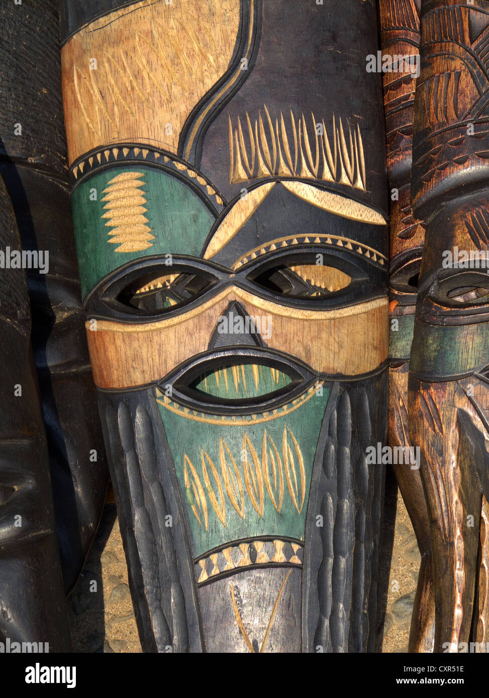 Decorated hand made wooden mask carved from the wood of an African tree Stock Photo